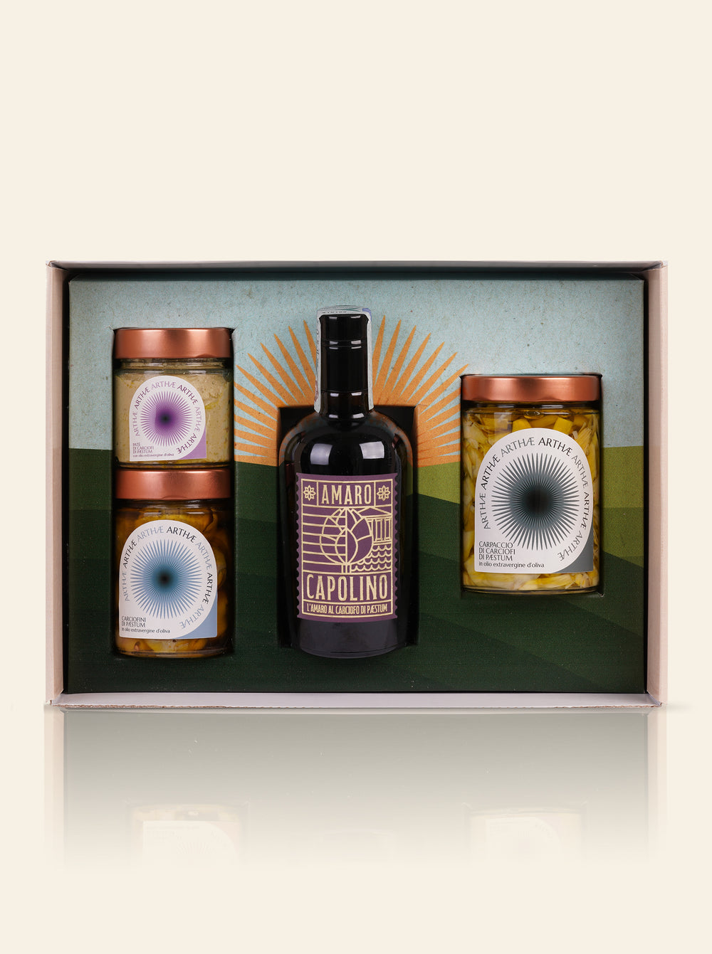 confezione regalo aperta che mostra 3 prodotti: 1 amaro e 3 vasetti sott'olio su sfondo beige