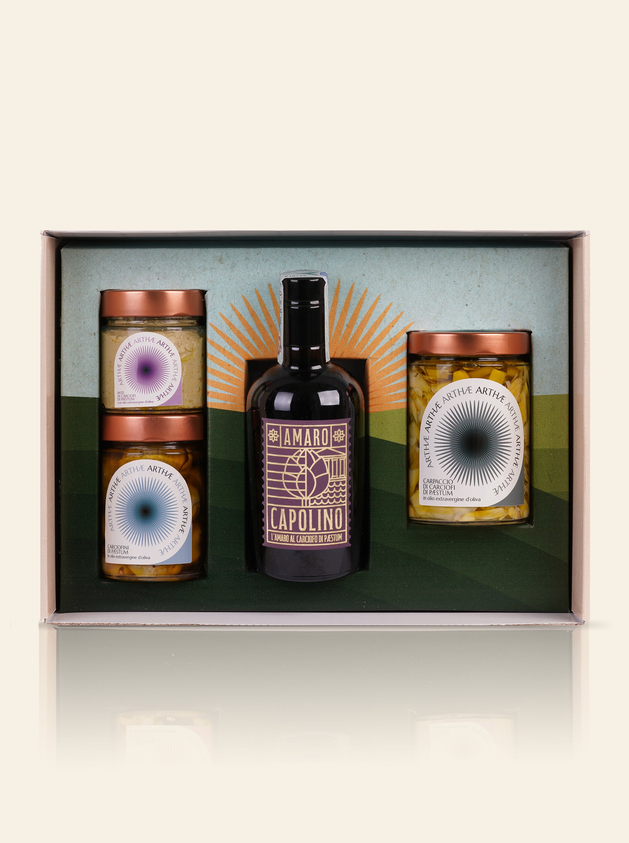 confezione regalo aperta che mostra 3 prodotti: 1 amaro e 3 vasetti sott'olio su sfondo beige