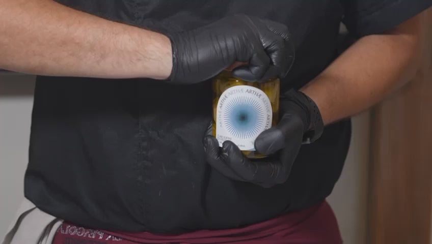 video che mostra l'impiattamento dei carciofini da parte di uno chef con guanti neri