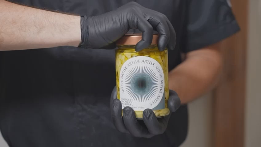 video che mostra l'impiattamento del carpaccio di carciofi da parte di uno chef con guanti neri