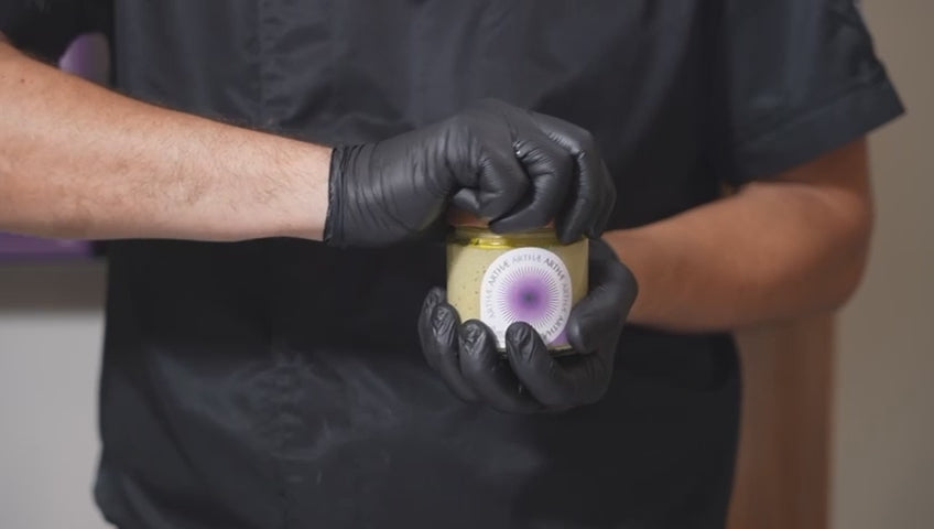 video che mostra l'impiattamento del patè di carciofi da parte di uno chef con guanti neri